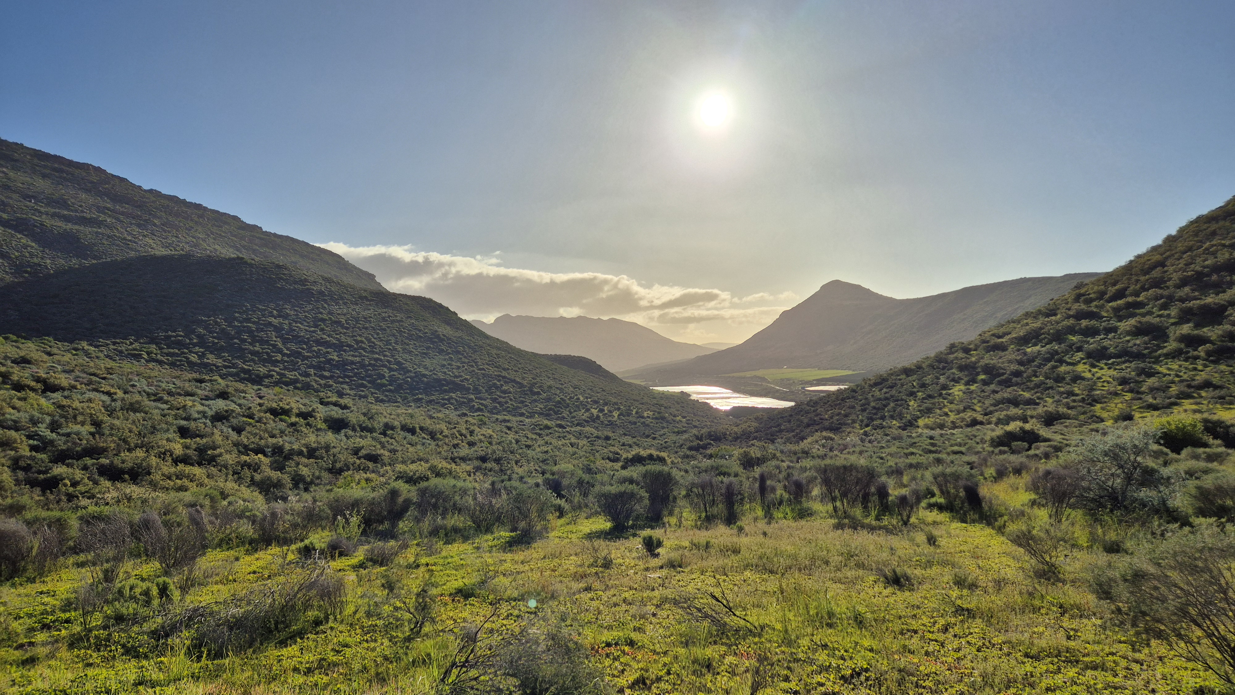Beautiful valley landscape with mountains and water body in distance
