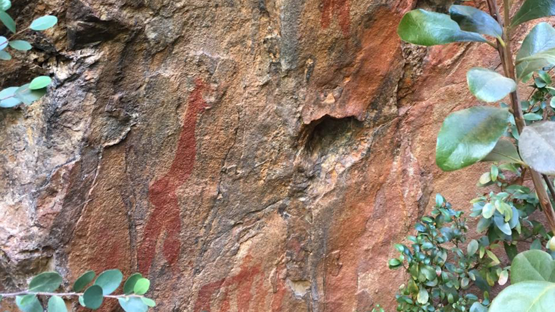 Ancient San rock art with red ochre paintings on sandstone